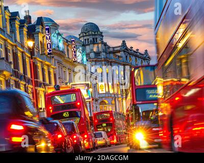 SHAFTESBURY AVENUE THEATRES NIGHT ULEZ LONDON TRAFFIC JAM SUNSET Theatreland traffic pollution blurred busy with red buses and taxis in Shaftesbury Avenue with Lyric Apollo & Gielgud Theatres featured West End London UK