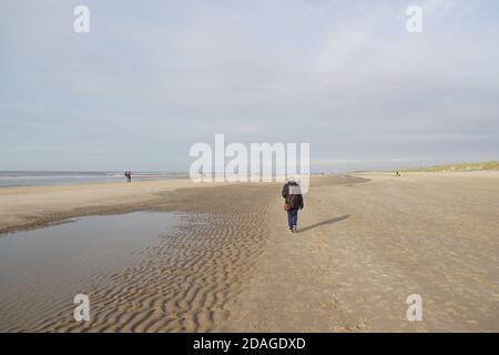 Walking on the beach with a wave pattern in the sand of the Dutch village of Bergen aan Zee in autumn. Netherlands, November Stock Photo