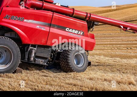 CaseIH combine with a broken rear axle awaits repair in a wheat field in the Palouse region of Eastern Washington Stock Photo