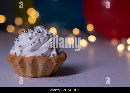 festive cupcake on the background of multi-colored balloons and lights. party, birthday concept. Copy space. High quality photo Stock Photo