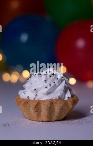 festive cupcake on the background of multi-colored balloons and lights. party, birthday concept. Copy space. High quality photo Stock Photo
