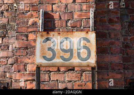 396 - rusty metal placard on industrial red brick building wall Stock Photo