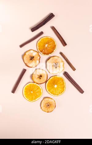 Festive Christmas tree made from cinnamon sticks, dried oranges and apples. Natural Christmas decor concept. Top view. Vertical orientation. Stock Photo