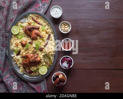 Homemade chicken Biryani. Arabic traditional food bowls Kabsa with meat. Top view, copy space. Stock Photo