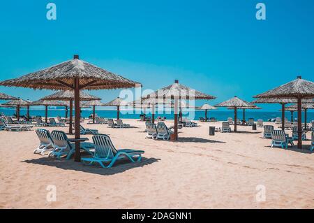 The beach with sunbeds and sunshades in Dubai, on the shores of the Arabian Gulf. Heavenly oasis in Ras al Khaimah. Stock Photo