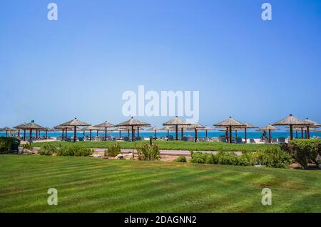 Vacation holidays beach background. The beach with sunbeds and sunshades in Dubai, on the shores of the Arabian Gulf Stock Photo