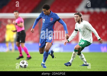 England's Jude Bellingham (left) goes past Republic of Ireland's Jeff Hendrick during the international friendly at Wembley Stadium, London. Stock Photo