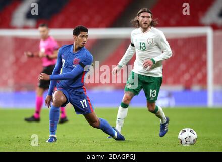 England's Jude Bellingham (left) goes past Republic of Ireland's Jeff Hendrick during the international friendly at Wembley Stadium, London. Stock Photo