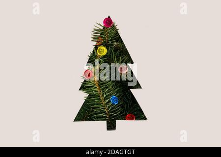 Negative space Christmas tree concept with Christmas tree branches and colorful buttons Stock Photo