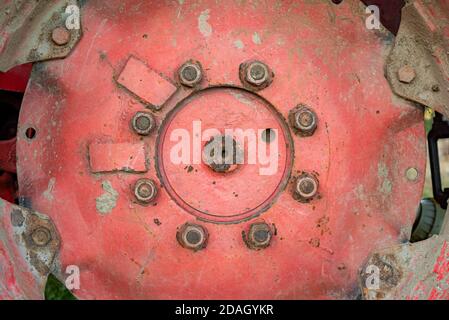 Close up of isolated red rusty rim tire big deep bolts of antique old tractor in Bulgaria Stock Photo