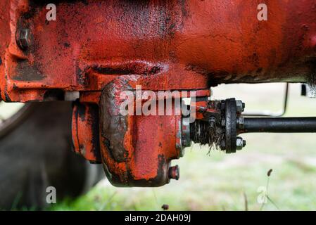 Closeup of old red rusty tractor transmission differential on russian agriculture transport machine historical during autumn harvest Stock Photo