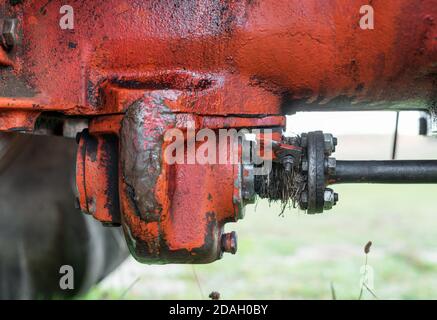 Closeup of old red rusty tractor transmission differential on russian agriculture transport machine historical during autumn harvest Stock Photo