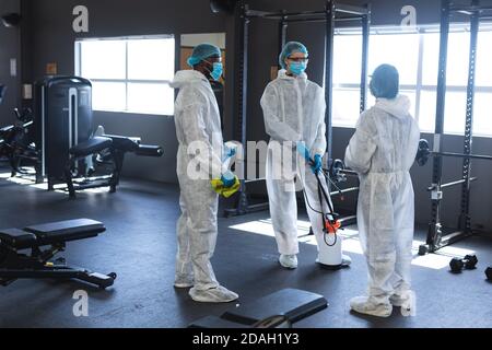 Team of workers wearing protective clothes discussing together in the gym Stock Photo