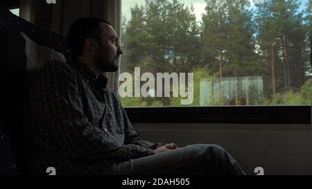 Sad young man looking through the window Stock Photo
