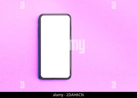 Smartphone on pink background. Trendy photo. Flat lay concept: devices for everyday life. Minimal style with colorful paper backdrop. Phone with blank screen, copy space. Stock Photo