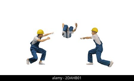 Three young construction workers in hard hats synch dancing look Stock Photo