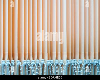 View of the vertical slats of peach-colored blinds. Parallel stripes. Abstract background. Stock Photo