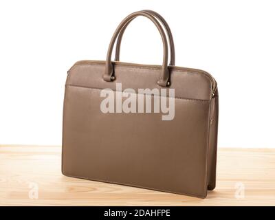 women's business bag on wooden table, isolated on white. brown leather women's handbag on white background Stock Photo
