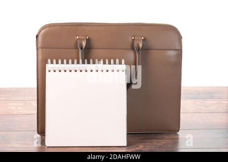 mockup of empty blank Notepad and business briefcase standing on the table. isolated on white background. planning a working day in the office Stock Photo