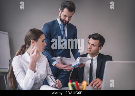 Three colleagues discussing the project in the office Stock Photo