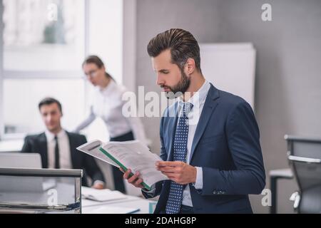 Serious business man in profile reading document Stock Photo