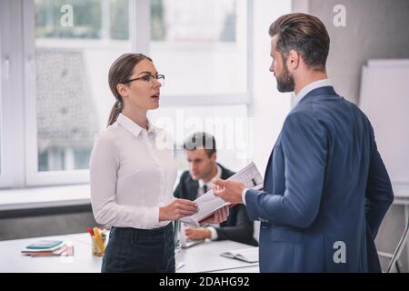 Woman with glasses and bearded man standing talking Stock Photo