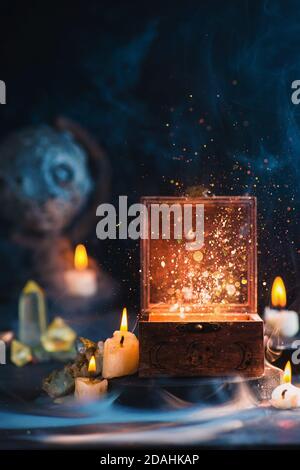 Magical box with stardust inside, witch workplace with candles, Moon glove Stock Photo