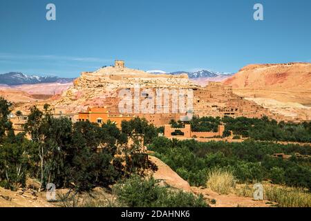 Scenic view of a famous moroccan berber village in the middle of sahara desert against a palm tree and clear blue sky, Ait Ben Haddou, Morocco, Africa Stock Photo