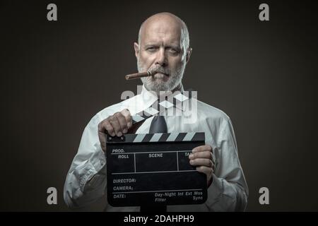 Middle-aged film director holding a clapperboard, cinematography and film industry concept Stock Photo