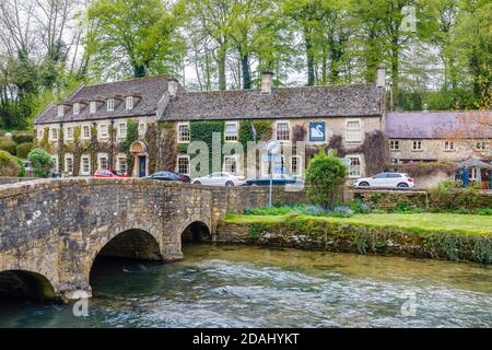 The Swan Hotel and Cotswold stone bridge over the River Coln in Bibury, a small pretty, unspoilt village Gloucestershire, in the Cotswolds Stock Photo