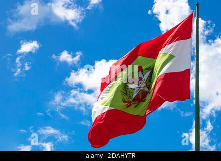 Low angle shot of the flag of Santa Catarina on a flagpole under a blue sky and sunlight in Brazil Stock Photo