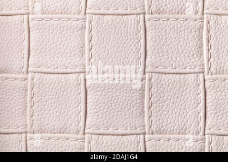 Texture of beige leather background with square pattern and stitch, macro. Abstract backdrop from modern decorative light cream textile with geometric Stock Photo