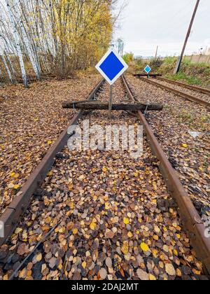 Wooden buffer stop with blue sign stop. The sign ending rail tracks concept for limit, limitation restrication. End of railway line Stock Photo