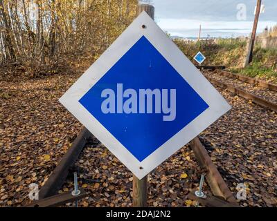 Wooden buffer stop with blue sign stop. The sign ending rail tracks concept for limit, limitation restrication. End of railway line Stock Photo