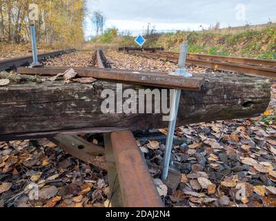 The sleeper screwed acrossing railway. Railroad with vanishing point. Railway track ending on a barrier Stock Photo