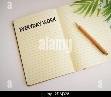 EVERYDAY WORK word written in notebook.Business concept for Refers to things or activities exist or happen every day.Free space for text. Copy space. Stock Photo