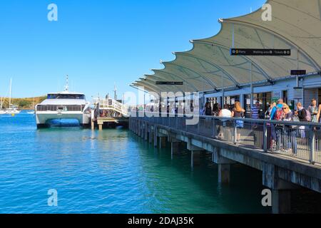 The wharf and ferry terminal on Waiheke Island, New Zealand, with a catamaran ferry tied up at the end Stock Photo