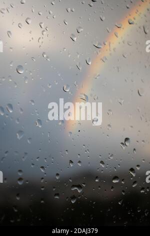 Rainbow seen thru a wet window with water drops Stock Photo