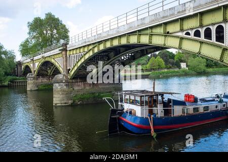 Barge moored on the River Thames under Richmond railway bridge. Stock Photo