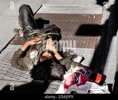 NEW YORK, USA - Sep 23, 2017: Manhattan street scene. A homeless man sleeps on the streets of Manhattan, NYC Stock Photo