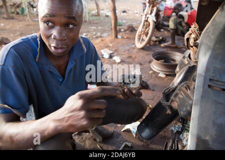 Selingue, Mali, 25th April 2015; Zoumana Coulibaly, 26, motorbike mechanic, has been working here for six years.  He repairs 3 or 4 bikes daily, and makes 3,500 to 5,000 CFA per day. Stock Photo