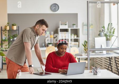 Two designers using laptop at the table they discussing online presentation in team at office Stock Photo