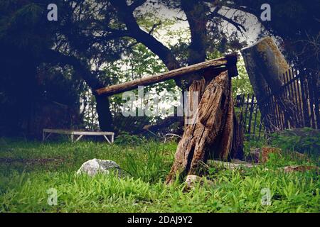 An old ax stuck in wood. Stock Photo