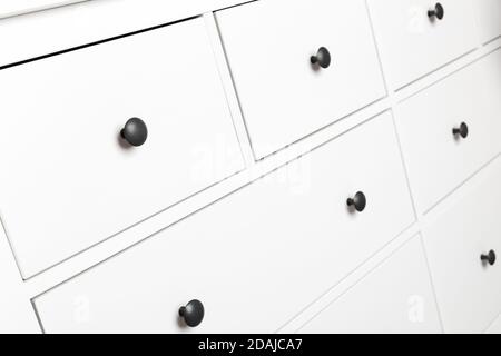 White wooden chest of drawers fragment, close up photo with selective focus Stock Photo