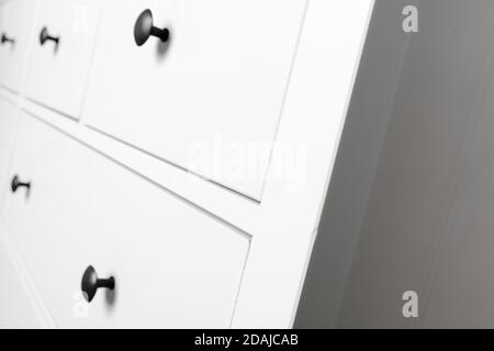 White wooden chest of drawers corner, close up photo with selective focus Stock Photo