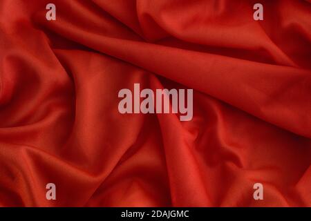 Red folded fabric texture background. Close up. Stock Photo