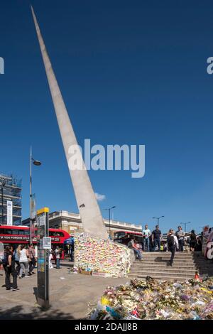 View looking north west with floral tributes and post-it notes stuck to the base of the needle as tributes to the terror attack victims of June 2017. Stock Photo