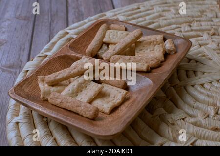 Closeup shot of biscuits in a wooden plate on a cork trivet Stock Photo