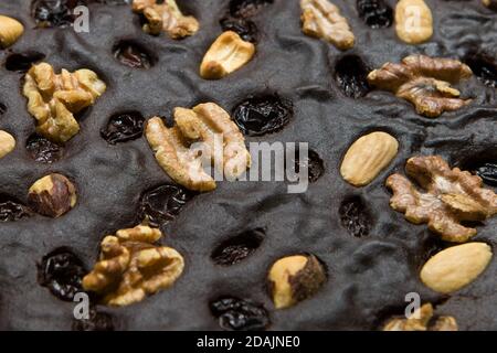 Brown, homemade walnut cake. Closeup background. Cake texture with raisins and walnuts close-up. Stock Photo