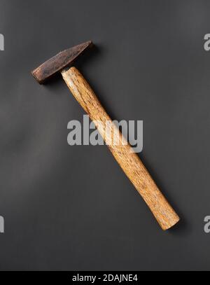 old scratched, rusty hand hammer with a wooden handle. Stock Photo